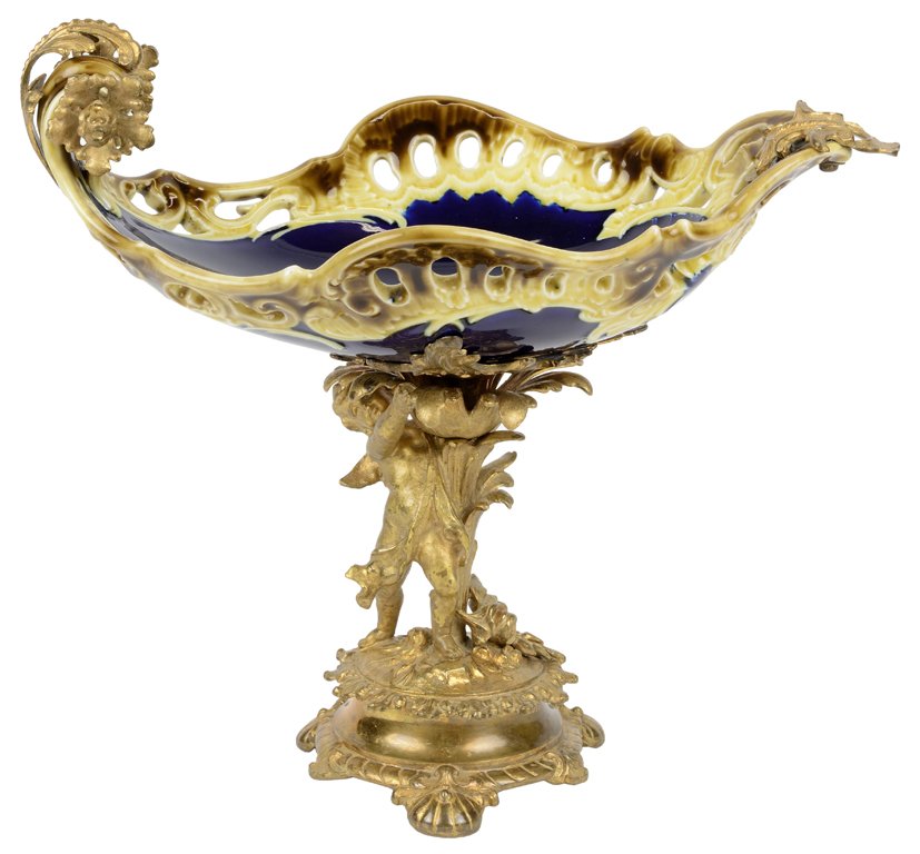 A KPM STYLE PORCELAIN CENTERPIECE WITH FIGURAL GILT: A KPM STYLE PORCELAIN CENTERPIECE WITH FIGURAL GILT BRONZE MOUNT Likely German, circa late 19th century The porcelain center bowl with reticulated edges and decorated in majolica style glazes, marked 