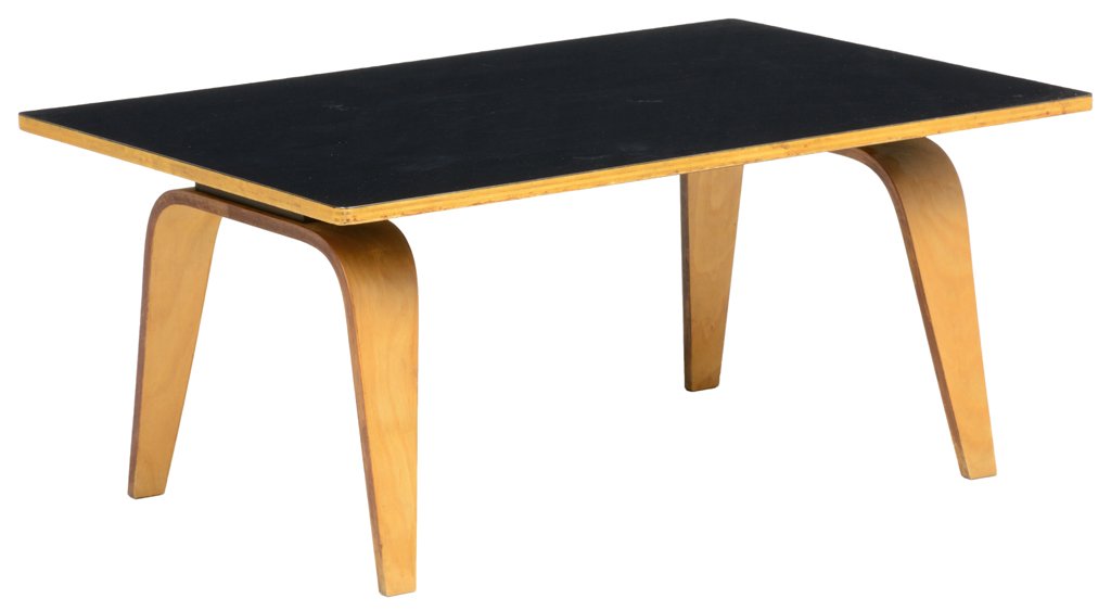 A CHARLES AND RAY EAMES STYLE BIRCH LOW TABLE: A CHARLES AND RAY EAMES STYLE BIRCH LOW TABLE The rectangular birch top having a black laminate surface, raised on curved and tapering molded birch and light plywood legs. H 15½ x W 35 x D 24 inches.