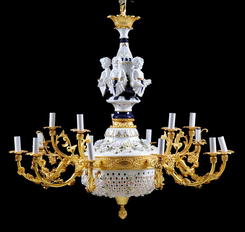 A BAVARIAN STYLE PORCELAIN AND GILT METAL FIFTEEN-LIGHT: A BAVARIAN STYLE PORCELAIN AND GILT METAL FIFTEEN-LIGHT CHANDELIER The gilt-metal upper mount descending to an inverted baluster-form standard with porcelain putti surrounds holding a garland of porce