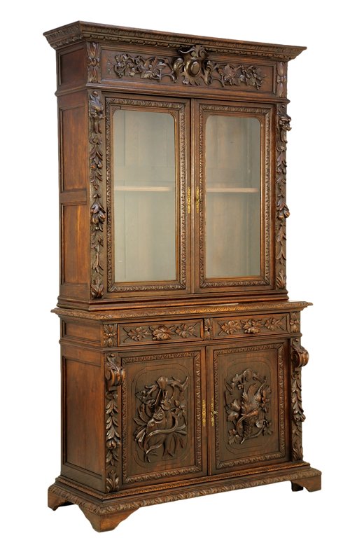 A RENAISSANCE REVIVAL VITRINE CABINET: A RENAISSANCE REVIVAL VITRINE CABINET The vitrine cabinet having a flared cornice over the shield and foliate carved frieze, over two glazed doors, opening to a shelved interior, over the rectangular 