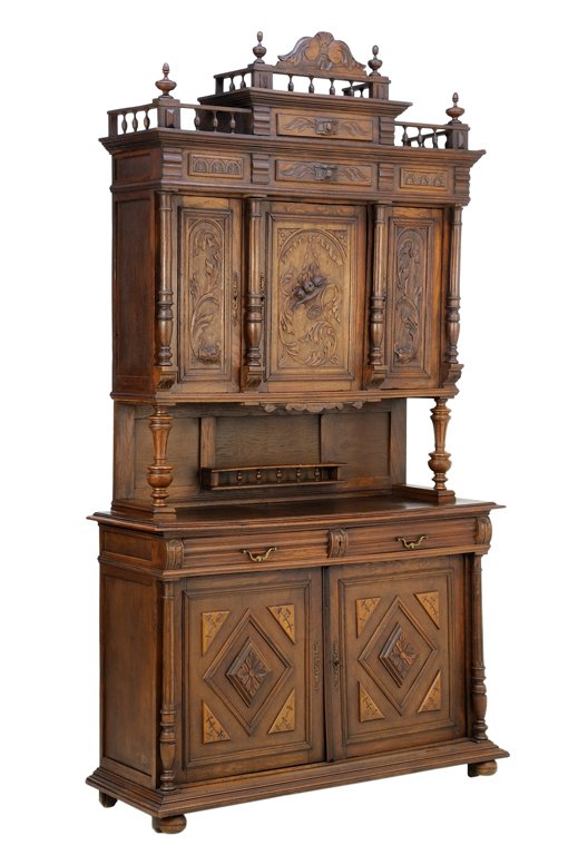 A RENAISSANCE REVIVAL OAK BUFFET A DEUX CORPS: A RENAISSANCE REVIVAL OAK BUFFET A DEUX CORPS Having a shell and foliate carved crest over the stepped three-quarter gallery pediment surmounted by turned finials, centered by two short drawers, above