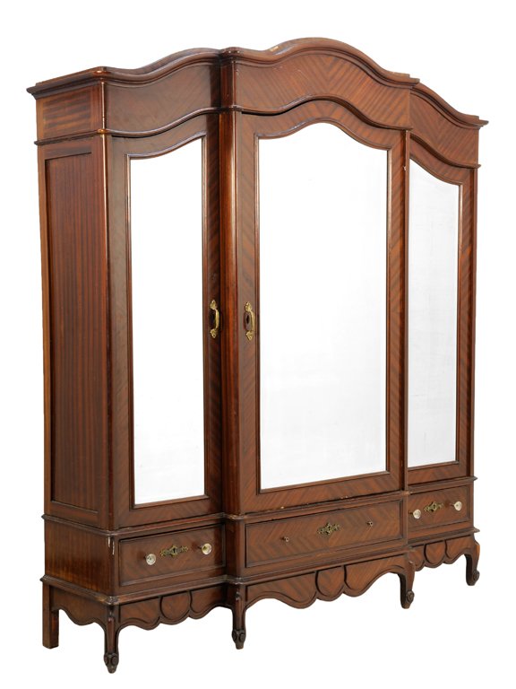 A FRENCH PROVINCIAL STYLE ARMOIRE: A FRENCH PROVINCIAL STYLE ARMOIRE Having a serpentine cornice over the conforming case, fitted with three mirror plate inset doors, over a long drawer flanked by two short drawers, over the shaped apr
