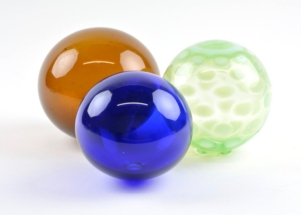 A GROUP OF THREE GLASS WITCH BALLS: A GROUP OF THREE GLASS WITCH BALLS H 5 x W 5 x D 5 inches. Provenance: Property from the Estate of John and Ann Hamilton, Houston, Texas Garth's, Ohio, 29 October 1993, catalog 450.