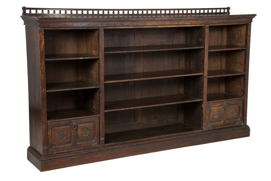 AN EDWARDIAN OAK BOOKCASE: AN EDWARDIAN OAK BOOKCASE Circa 1905 The bookcase having a spindled galleried cornice over the rectangular flared pediment over a series of shelves and two drop-down doors, ending in a plinth base. H 