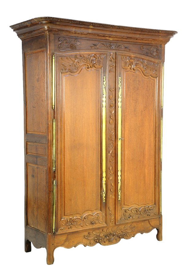 A FRENCH LOUIS XV STYLE ARMOIRE: A FRENCH LOUIS XV STYLE ARMOIRE The armoire having a flared pediment over the conforming case, carved with foliate decoration over two paneled doors, with gilt metal escutcheon, above the serpentine a