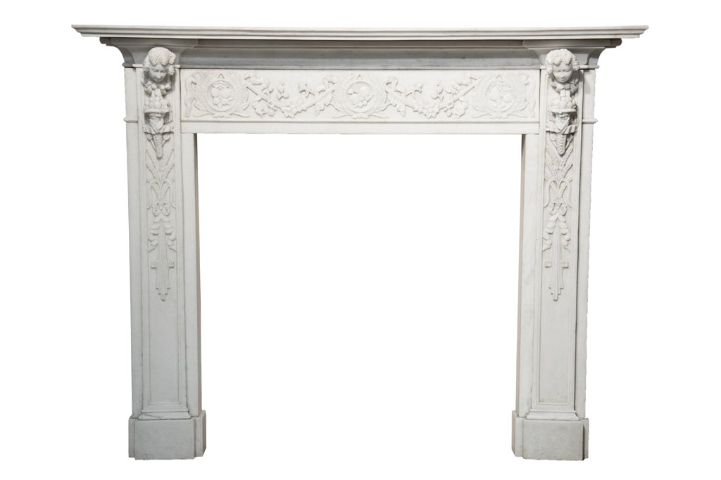 A CONTINENTAL CARVED MARBLE FIREPLACE: A CONTINENTAL CARVED MARBLE FIREPLACE The fireplace having a flared mantel over the foliate and mask carved frieze, raised on twin supports. H 59½ x W 76 x D 13 inches.