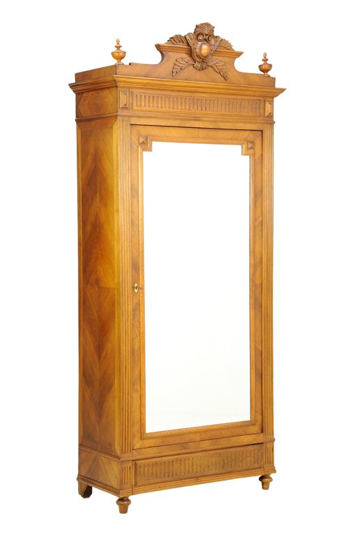 A FRENCH LOUIS XVI STYLE ARMOIRE: A FRENCH LOUIS XVI STYLE ARMOIRE The stepped pediment having two urn form finials, centered with a scrolling foliate shield crest, over a single mirror inset door with a keyhole surround escutcheon, r