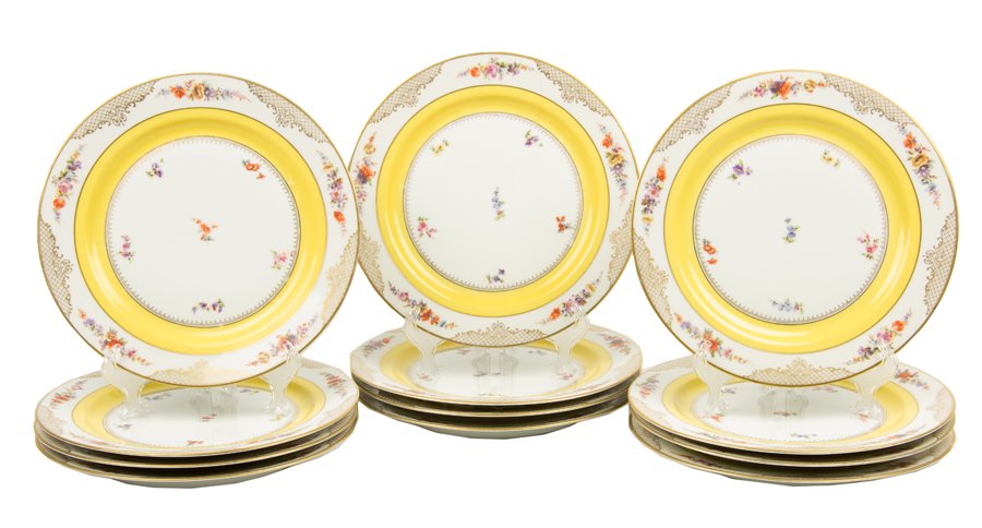 TWELVE BAVARIAN TIRSCHENREUTH PORCELAIN PLATES: TWELVE BAVARIAN TIRSCHENREUTH PORCELAIN PLATES Having transfer and parcel gilt decoration centering floral motifs within a yellow and gilt mesh border, marked to reverse. Diam 10¾ inches.