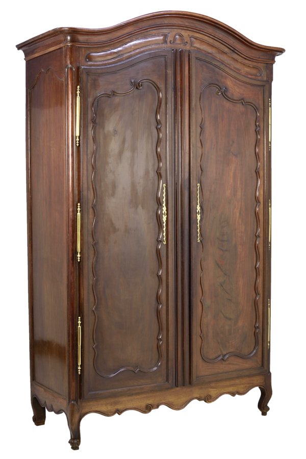 A FRENCH LOUIS XV STYLE MAHOGANY ARMOIRE: A FRENCH LOUIS XV STYLE MAHOGANY ARMOIRE The armoire having a domed cornice centered over the conforming case fitted with two paneled doors, over the serpentine apron, raised on scrolled fore feet. H 
