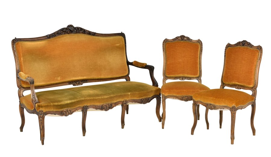 A FRENCH LOUIS XV/XVI TRANSITIONAL STYLE SALON SUITE: A FRENCH LOUIS XV/XVI TRANSITIONAL STYLE SALON SUITE The suite comprising a settee, two armchairs and two side chairs. Each having a foliate carved crest rail over the upholstered back and seat, over 