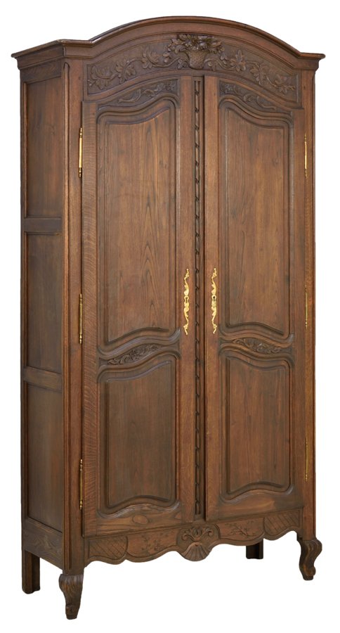 A FRENCH PROVINCIAL STYLE OAK ARMOIRE: A FRENCH PROVINCIAL STYLE OAK ARMOIRE The armoire having a curved cornice over the frieze carved with an urn and foliate crest over the conforming case fitted with two paneled doors, over the serpenti