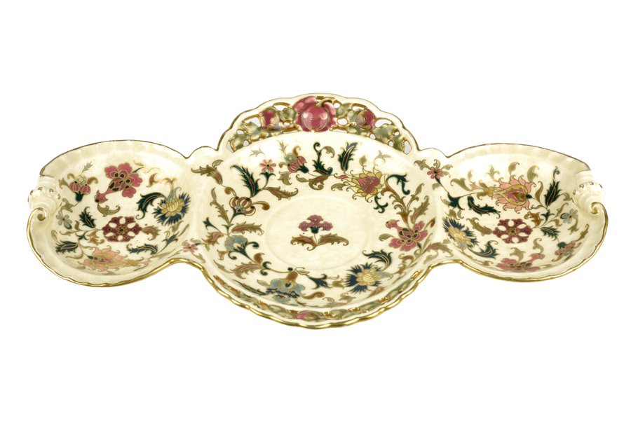 A ZSOLNAY RETICULATED PORCELAIN DISH: A ZSOLNAY RETICULATED PORCELAIN DISH Pecs, Hungary, of elongated ovoid form with scrolled ends, the central well divided into three circular segments and decorated throughout in polychrome enamels bet