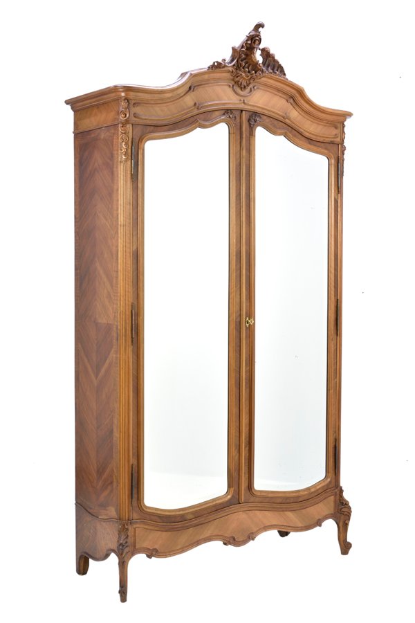 A FRENCH LOUIS XV STYLE ARMOIRE: A FRENCH LOUIS XV STYLE ARMOIRE The armoire having a pierce carved acanthus leaf crest over the domed cornice and conforming case fitted with double mirror plate inset doors, over the serpentine apron