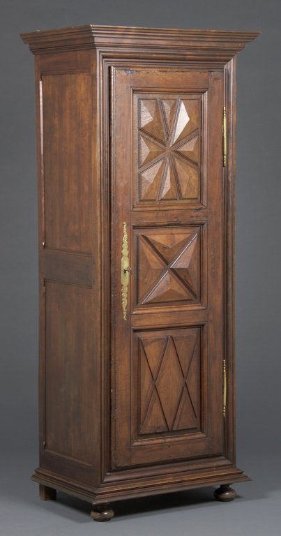 A FRENCH LOUIS XIII STYLE ARMOIRE: A FRENCH LOUIS XIII STYLE ARMOIRE The armoire having a flared cornice over a single paneled door, coffer panel sides, ending in a flared base, raised on squat ball feet. H 77½ x W 32½ x D 21¾ inche