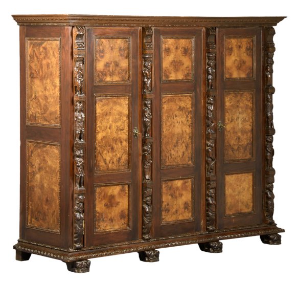 A RENAISSANCE REVIVAL BURL WALNUT AND MAHOGANY ARMOIRE: A RENAISSANCE REVIVAL BURL WALNUT AND MAHOGANY ARMOIRE 19th century The armoire having a flared cornice above three paneled doors flanked by figural decoration, raised on a plinth base, ending in brac