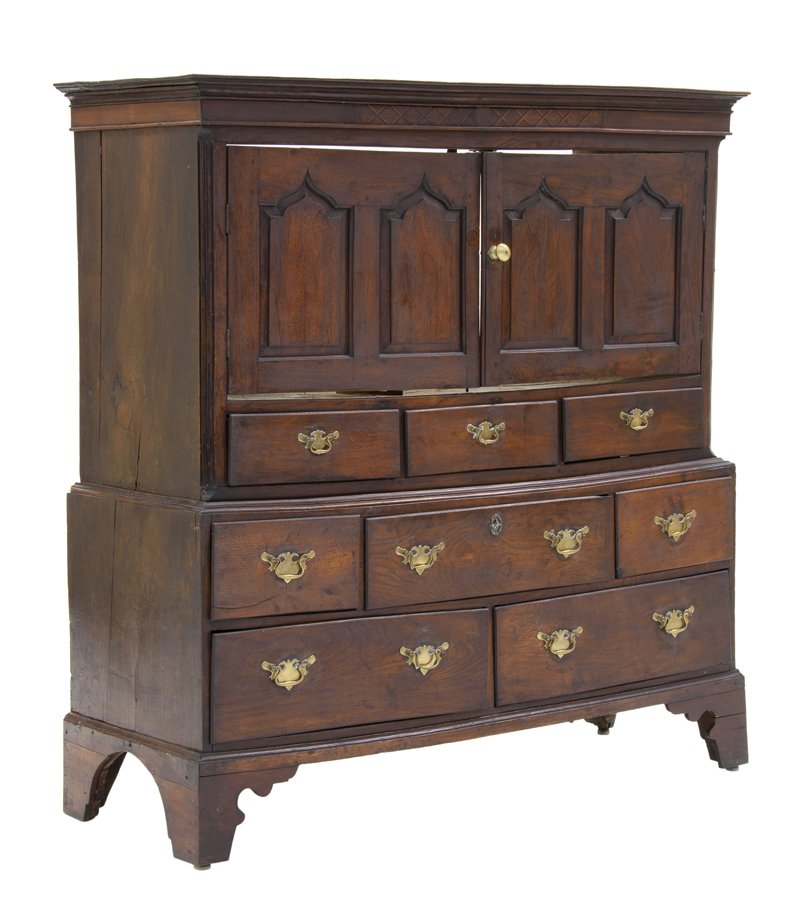 A GEORGIAN OAK CUPBOARD: A GEORGIAN OAK CUPBOARD 18th century with later adaptations The cupboard having a rectangular top and flared cornice above the conforming case, fitted with two paneled doors, over a series of drawers,