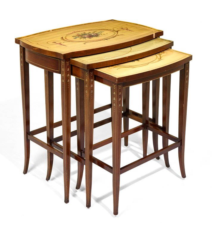 A SET OF SHERATON STYLE MAHOGANY AND DECORATED: A SET OF SHERATON STYLE MAHOGANY AND DECORATED SERPENTINE NESTING TABLES Each table having a shaped rectangular top with floral decoration, raised on square tapering legs, joined by stretchers. H 26¼