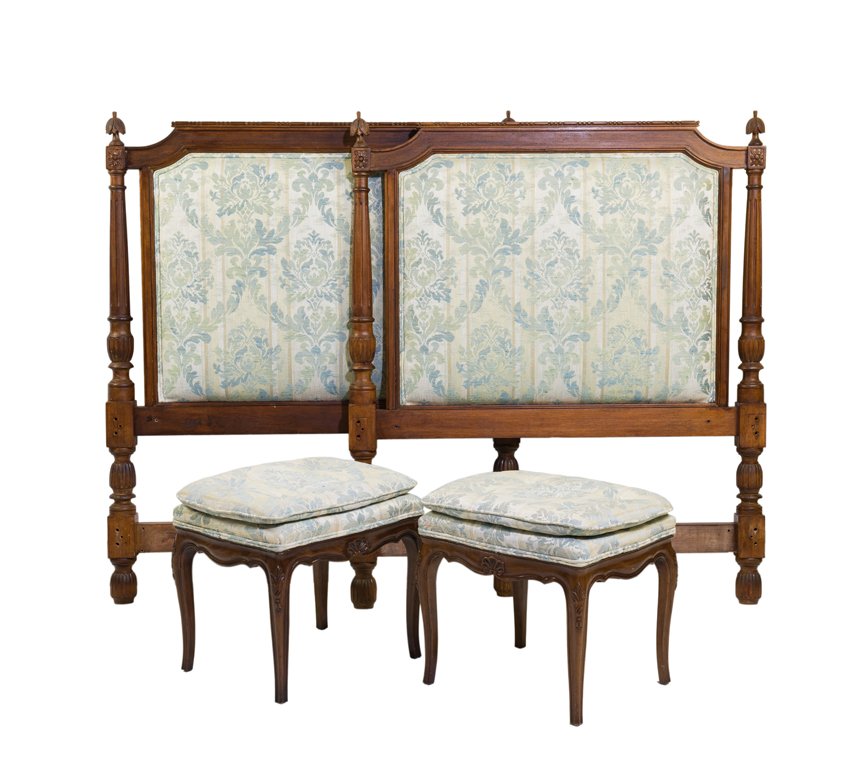 A PAIR OF FRENCH UPHOLSTERED WALNUT HEADBOARDS AND FOOT: A PAIR OF FRENCH UPHOLSTERED WALNUT HEADBOARDS AND FOOT STOOLS 20th century Each headboard having a straight top rail flanked by urn form finials above the upholstered headboard. Together with a pair