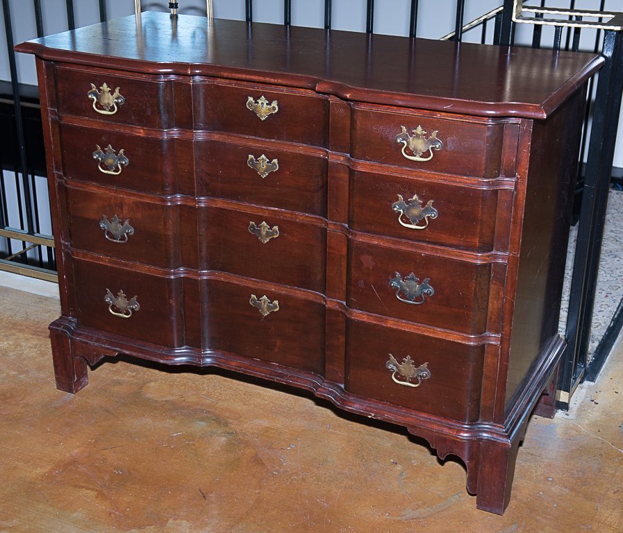 A MAHOGANY CHEST OF DRAWERS: A MAHOGANY CHEST OF DRAWERS The reverse serpentine top over four long drawers, with bat wing drop handle brass fixtures, the whole raised on bracket feet. H 34¼ x W 46¼ x D 19¾ inches
