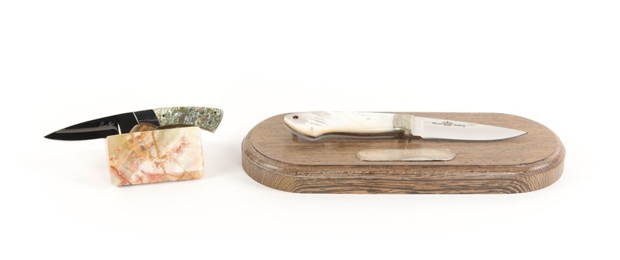 A MOTHER-OF-PEARL AND AN ABALONE HANDLED KNIFE: A MOTHER-OF-PEARL AND AN ABALONE HANDLED KNIFE 20th century Comprising a Thomas Anthony knife with a mother-of-pearl handle, mounted on a veneered base with plaque reading 'To Hank - From Henry Anchor