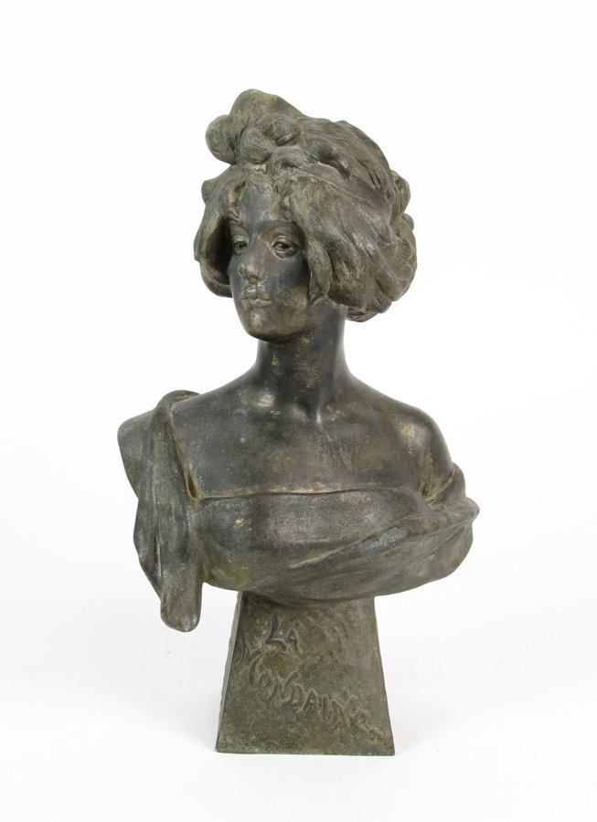 A CAST METAL BUST OF A WOMAN: A CAST METAL BUST OF A WOMAN Modeled looking slightly to one side, on a trapezoid form base marked 'LA MONDAINE' to the front. H 17¼ Provenance: Property from the Collection of Wade Warnken, Houston,