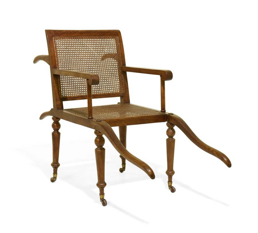 A CAMPAIGN SEDAN CHAIR: A CAMPAIGN SEDAN CHAIR Late 19th century The sedan chair having a straight crest rail over the caned back and seat, within open arms, raised on tapering legs, ending in casters. H 38½ x W 21 x D 48 i