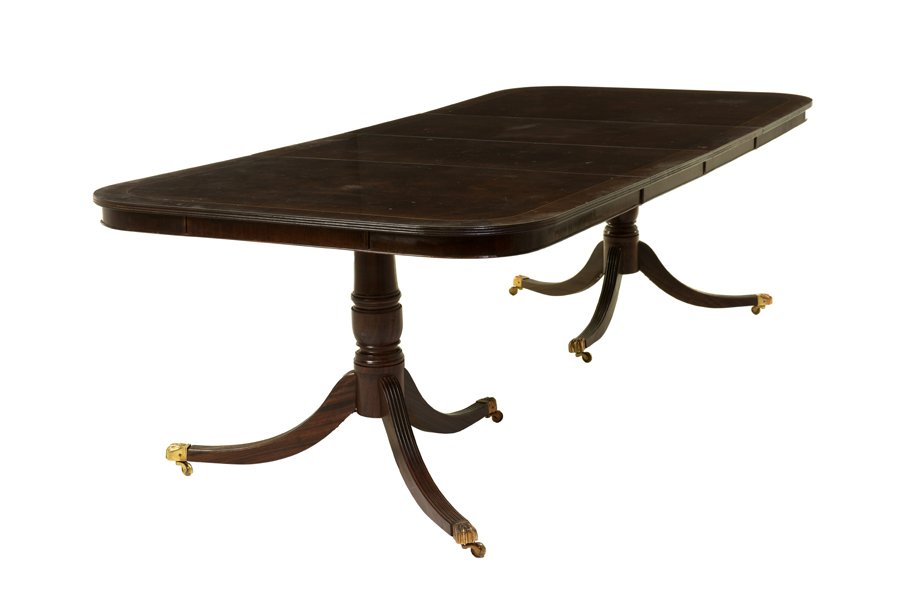 A GEORGE III STYLE MAHOGANY AND SATINWOOD CROSSBANDED: A GEORGE III STYLE MAHOGANY AND SATINWOOD CROSSBANDED TWO-PILLAR DINING TABLE 19th century The dining table having a rectangular top with rounded corners, raised on twin pillars and splayed legs endin
