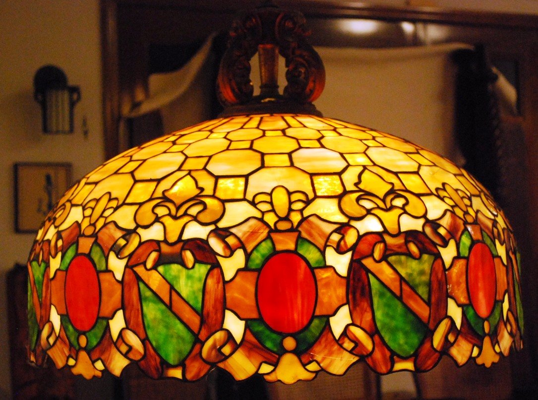 American Stained Glass Hanging Lamp: Attributed to Tiffany Studios, Unsigned, 1900, Bronze mounted hanging glass dome. 6 Light illuminator 27" wide x 15" tall