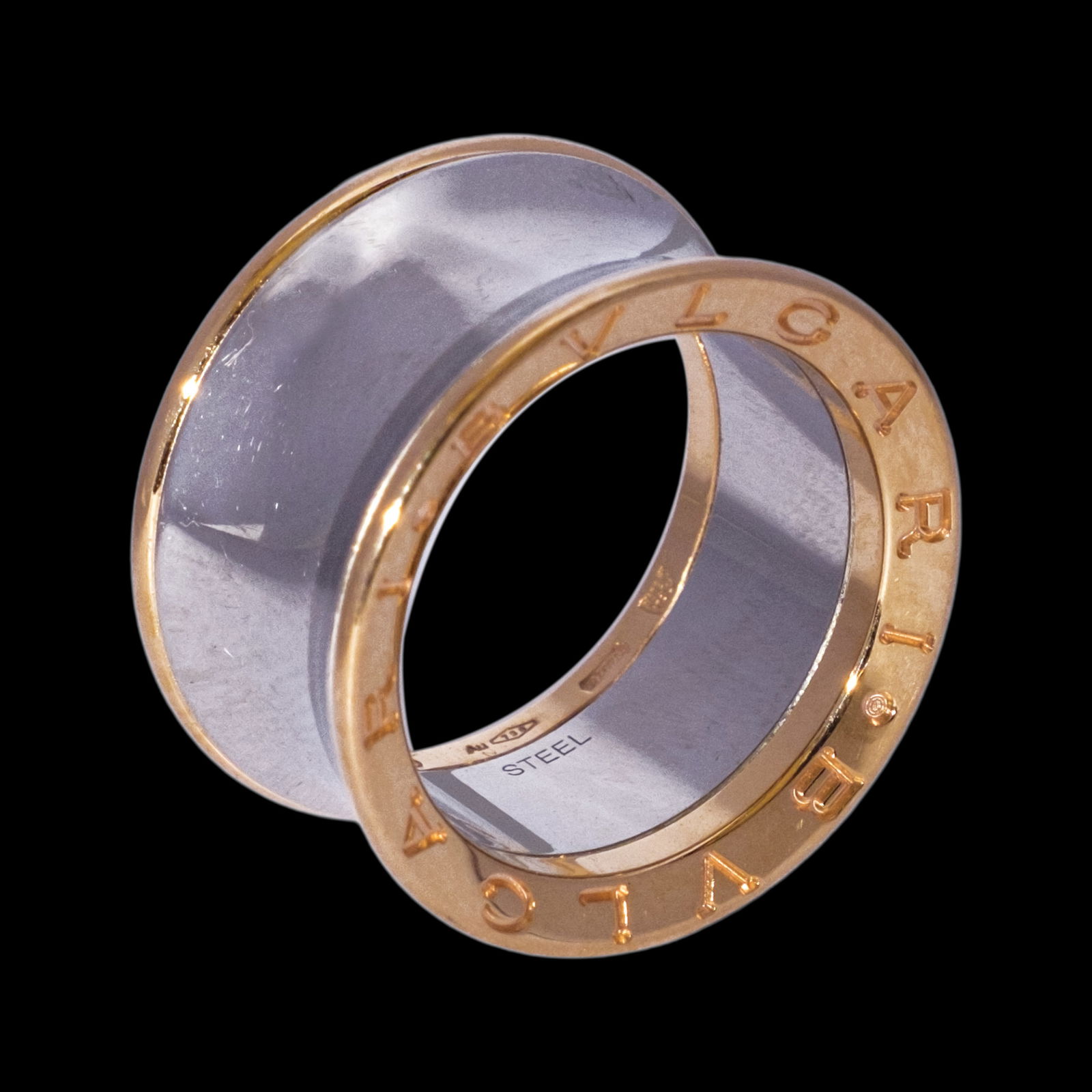 Bvlgari Anish Kapoor Ring: The iconic B.Zero 1 ring updated by anishKapoor, replacing the spirals with a defined,hourglass silhouette. The B. Zero1 ring is castin stainless steel and edges are secured by 18ktrose gold with sign
