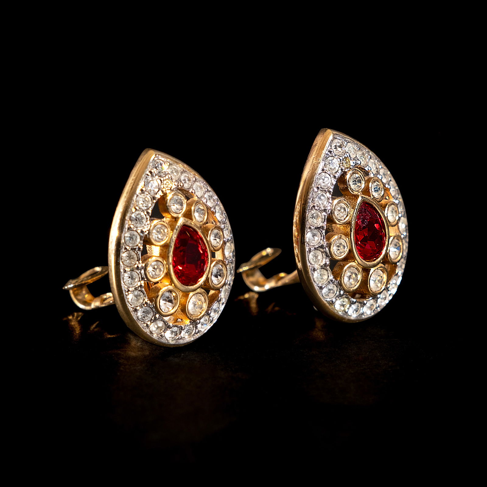 A Pair of Swarvoski Earrings: The classic pair of gold-plated Swaroksi earringsfeature a pear-shaped red Swarovski crystal inthe center accented by surrounding clear roundcrystals. Signed with Swarovski maker’s mark. Weighs