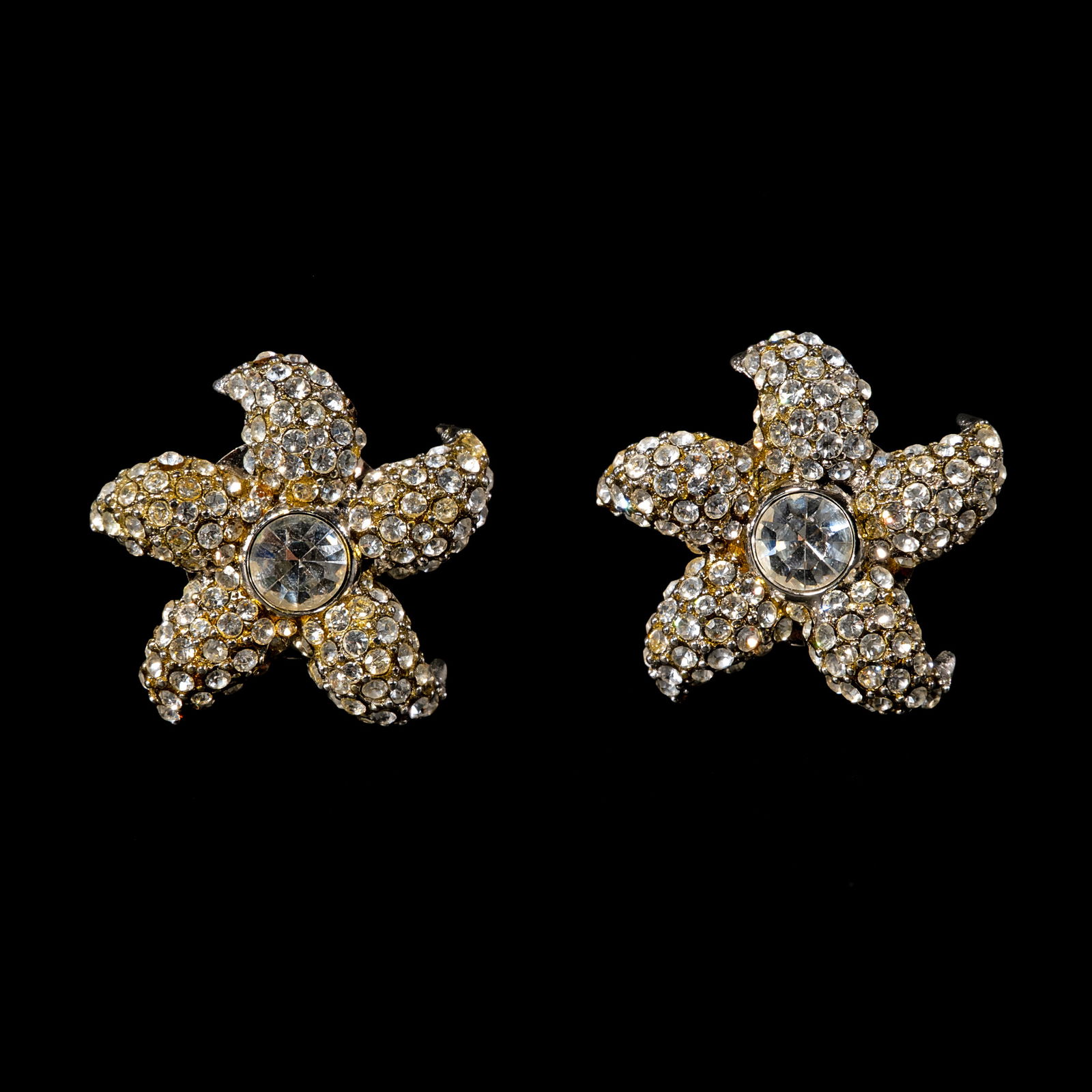A Pair of Starfish Earclip Accessories: The dazzling starfish earclips is centered bya large crystal surrounded by rays encrustedwith foil-back crystals. Weighs 34.0 grams.