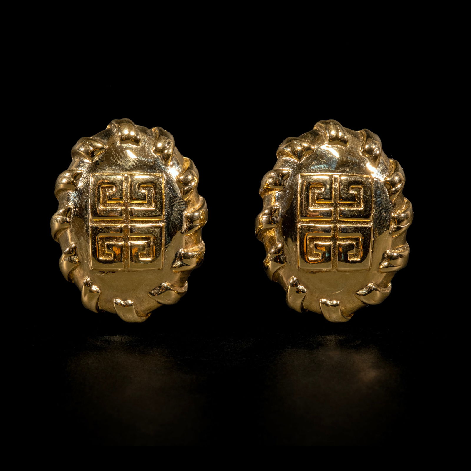 A Pair of 1980s Givenchy 4G Emblem Earclips: The bold, chunky gold-plated earclips showcasethe iconic Givenchy 4G emblem. Signed Paris New York Givenchy with maker’smark. Weighs 30.90 grams.