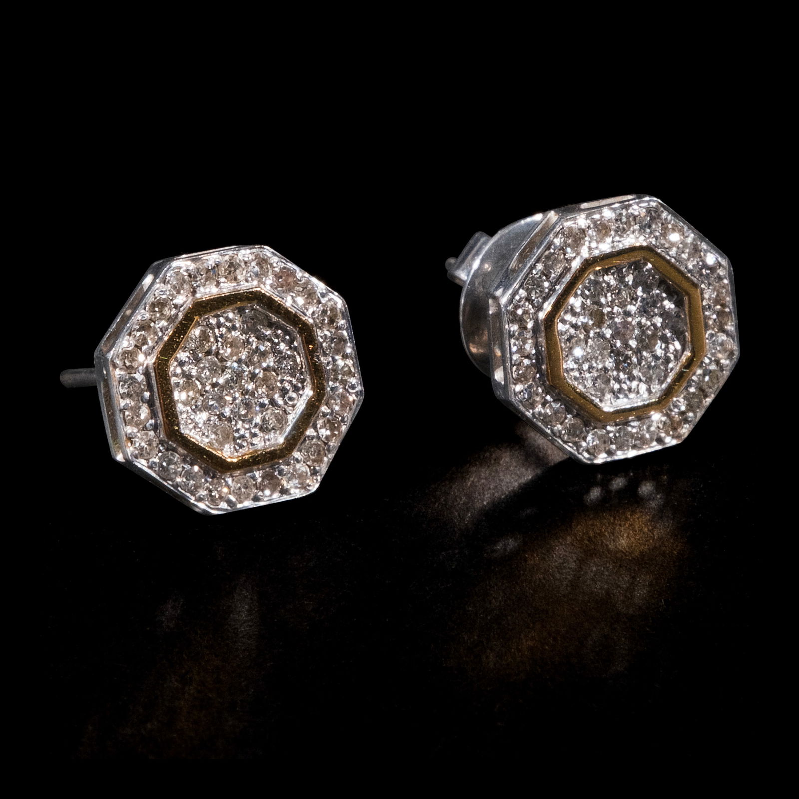 A Pair of Diamond Pavé Studs in 14k: The earring studs in two-toned yellow andwhite gold feature an octagon design fullyencrusted with diamond pavé weighingapproximately 0.74 cts. Weighs 5.50 grams. Some stones noted as Refer on t