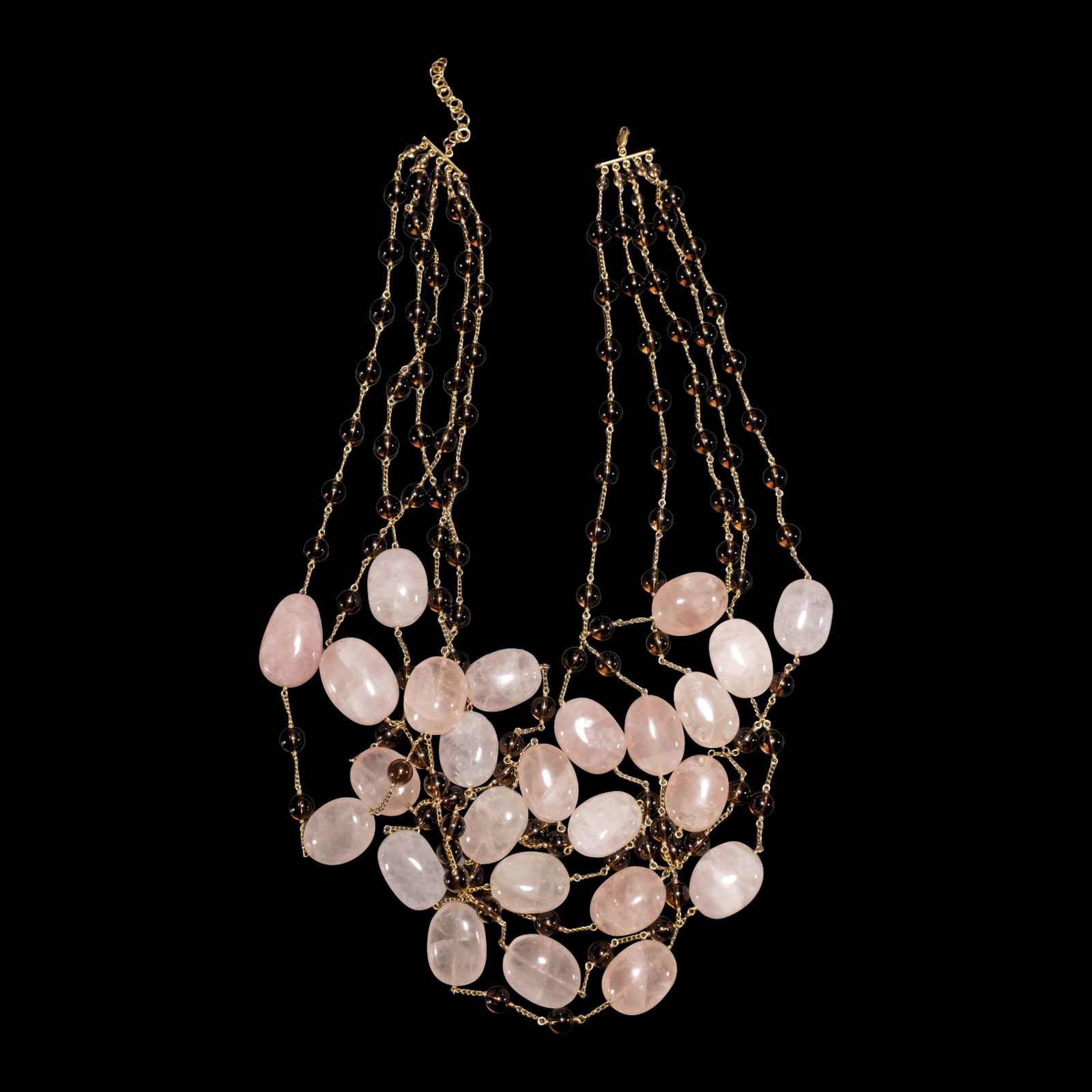 A Five-strand Multi-gem Necklace in 14k: The statement necklace features five strands ofround-shaped brown beads and oval-shapedpink beads connected by 14k yellow goldchain. Weighs 333.20 grams.