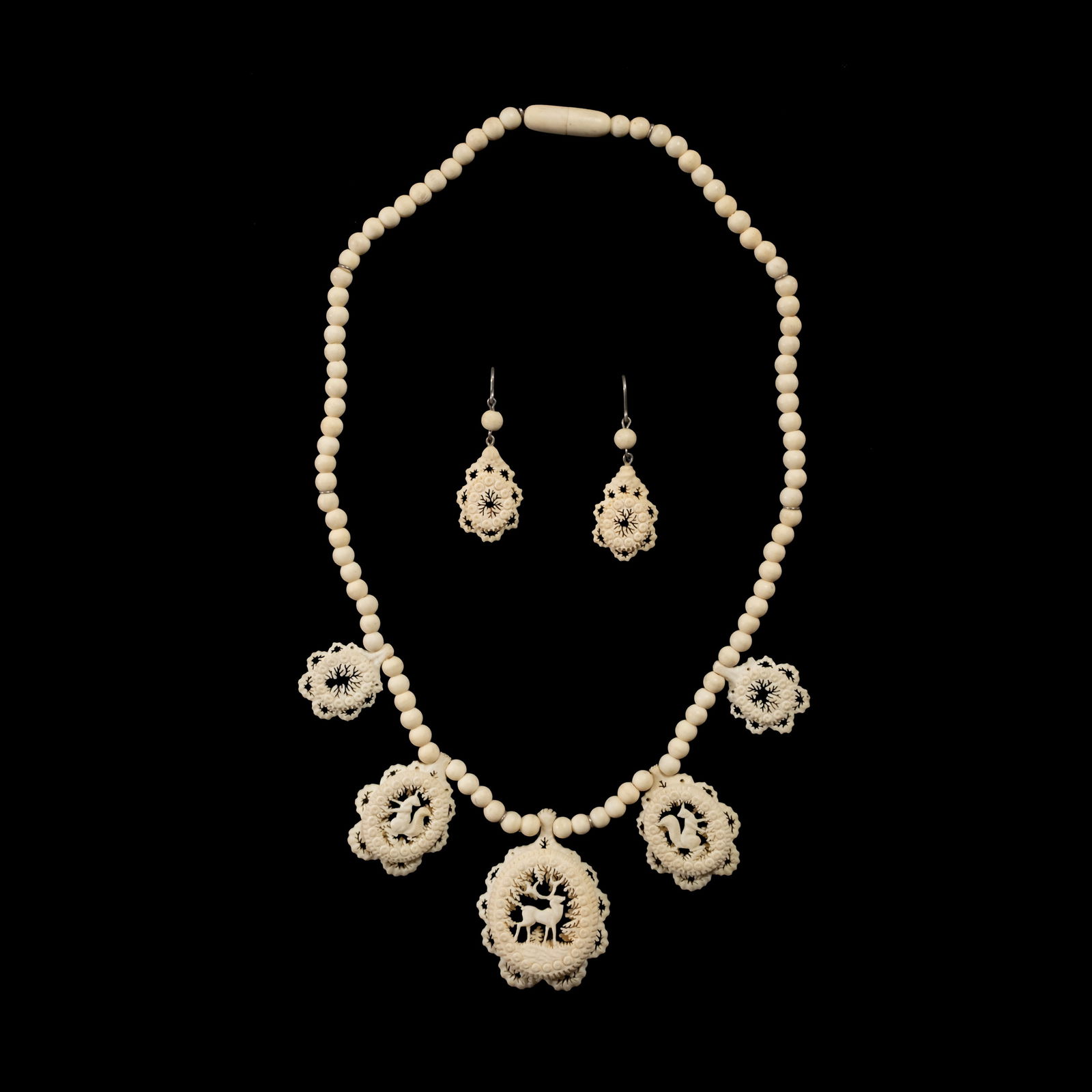 A Set of Carved Bone Jewelry: The set includes a 16-inch necklace andmatching earrings, meticulously carved frombone with intricate nature motifs. Weighs 17.90 and 2 grams. The necklace length is 16 inches.
