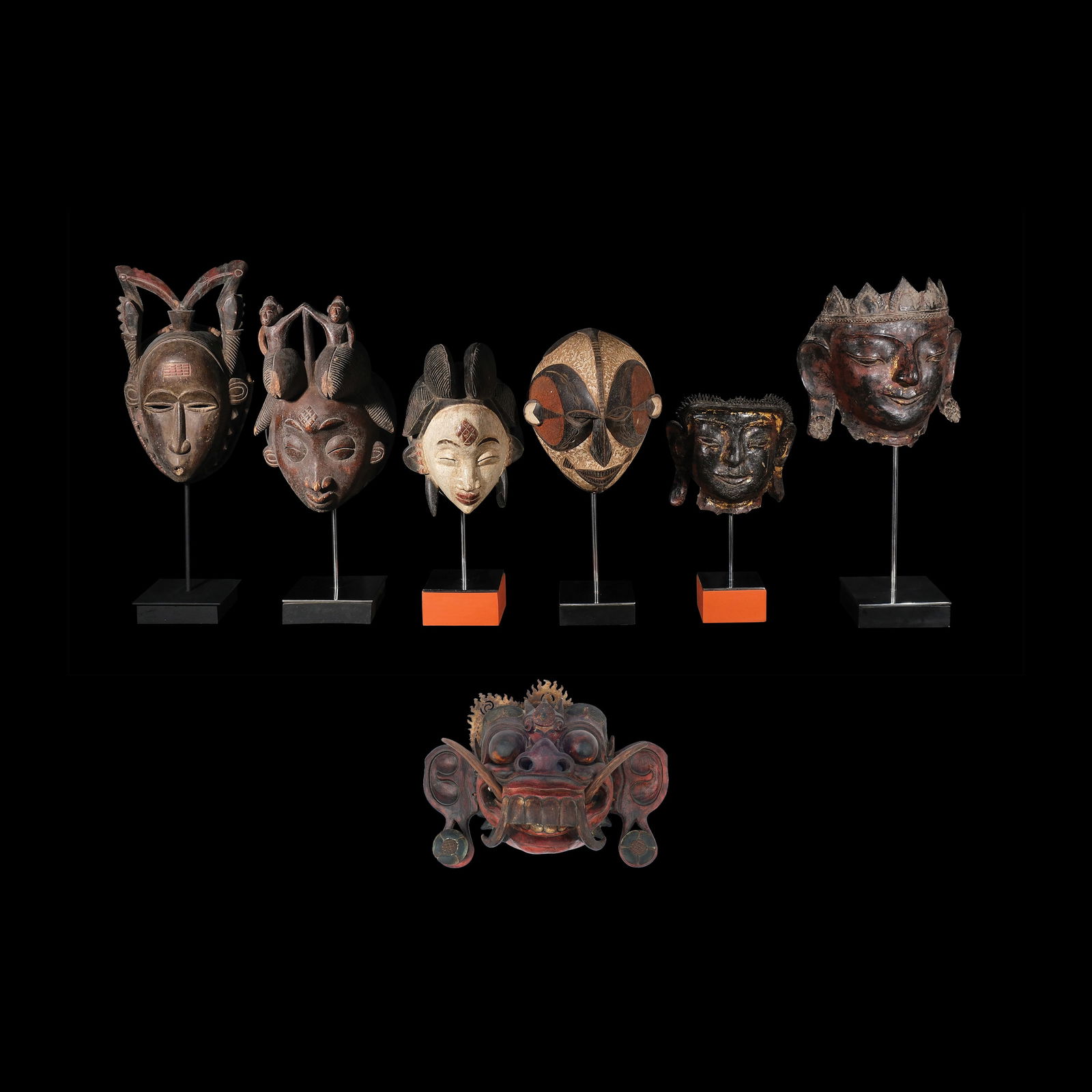 Six Masks Mounted on bases: PROPERTY OF A DISTINGUISHED LADY polychromed hardwooda.) H: 24” (61 cm)L: 8” (20 cm)W: 5 1/4” (13 cm) b.) H: 22 1/4” (57 cm)L: 9” (23 cm)W: 6 3/4” (17 cm)<