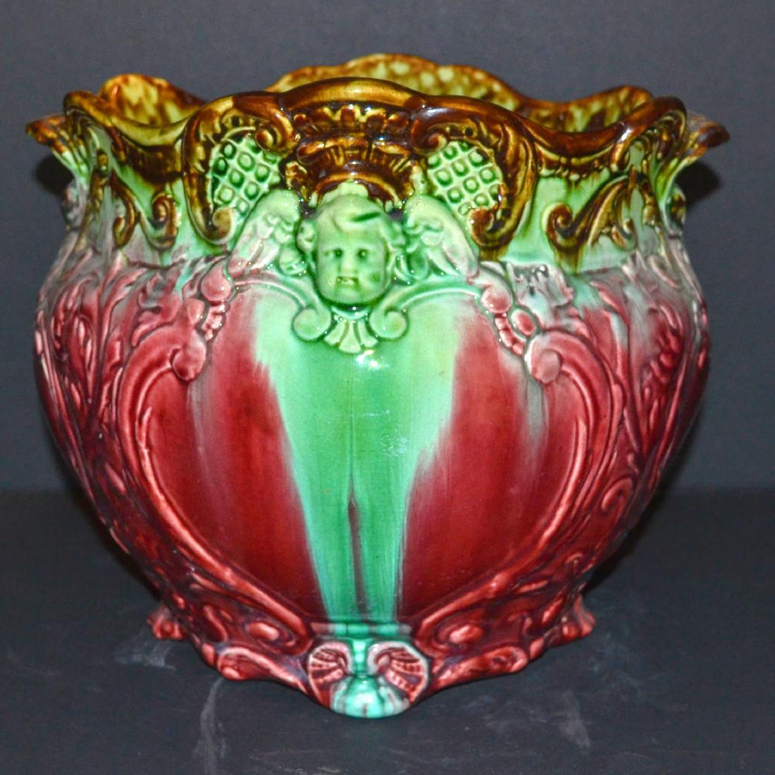 Antique Majolica Vase: Antique Majolica vase, Cherub dipictions, reds,greens and browns 9 1/2 " h 13" d