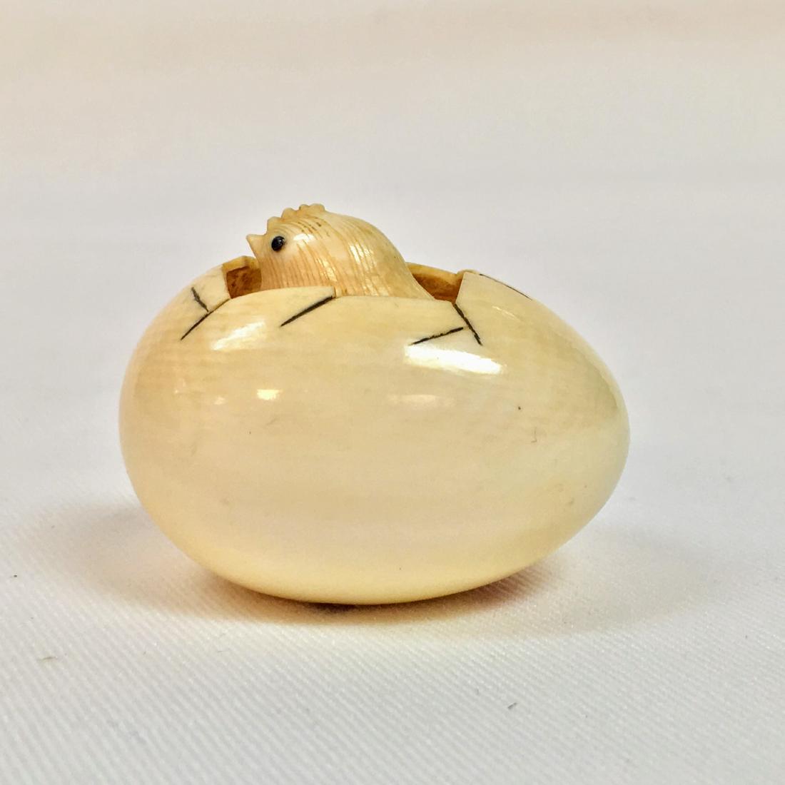 A carved Netsuke figure of a small chick cracking his (1 of 7)