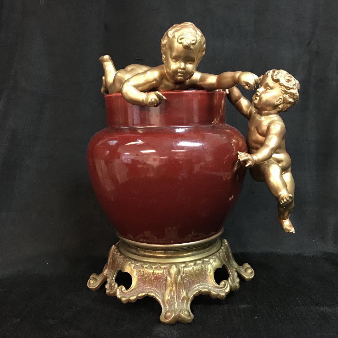 antique french 19 century Sang de boeuf porcelain and: antique french 19 century Sang de boeuf porcelain and cherud vase, Measures 10" x 9"
