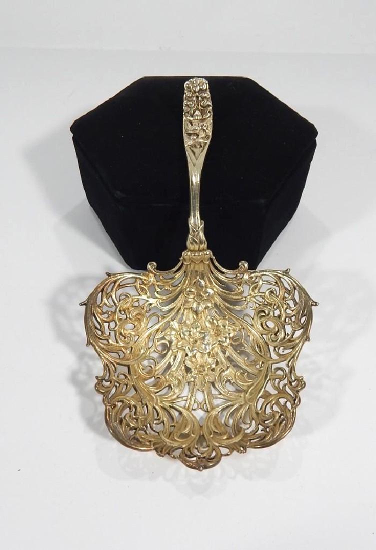 Calt & Bro Sterling Silver Spoon: A sterling silver pierced floral spoon by Calt & Bro.Measures: 7.5" x 4.25" Weighs 153.3 grams.