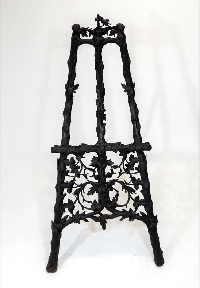 Antique Black Forest Walnut Easel: Wonderful early Black Forest walnut easel, the supports carved into branches and decorated with swags of leaves. Width:36" Height: 80"