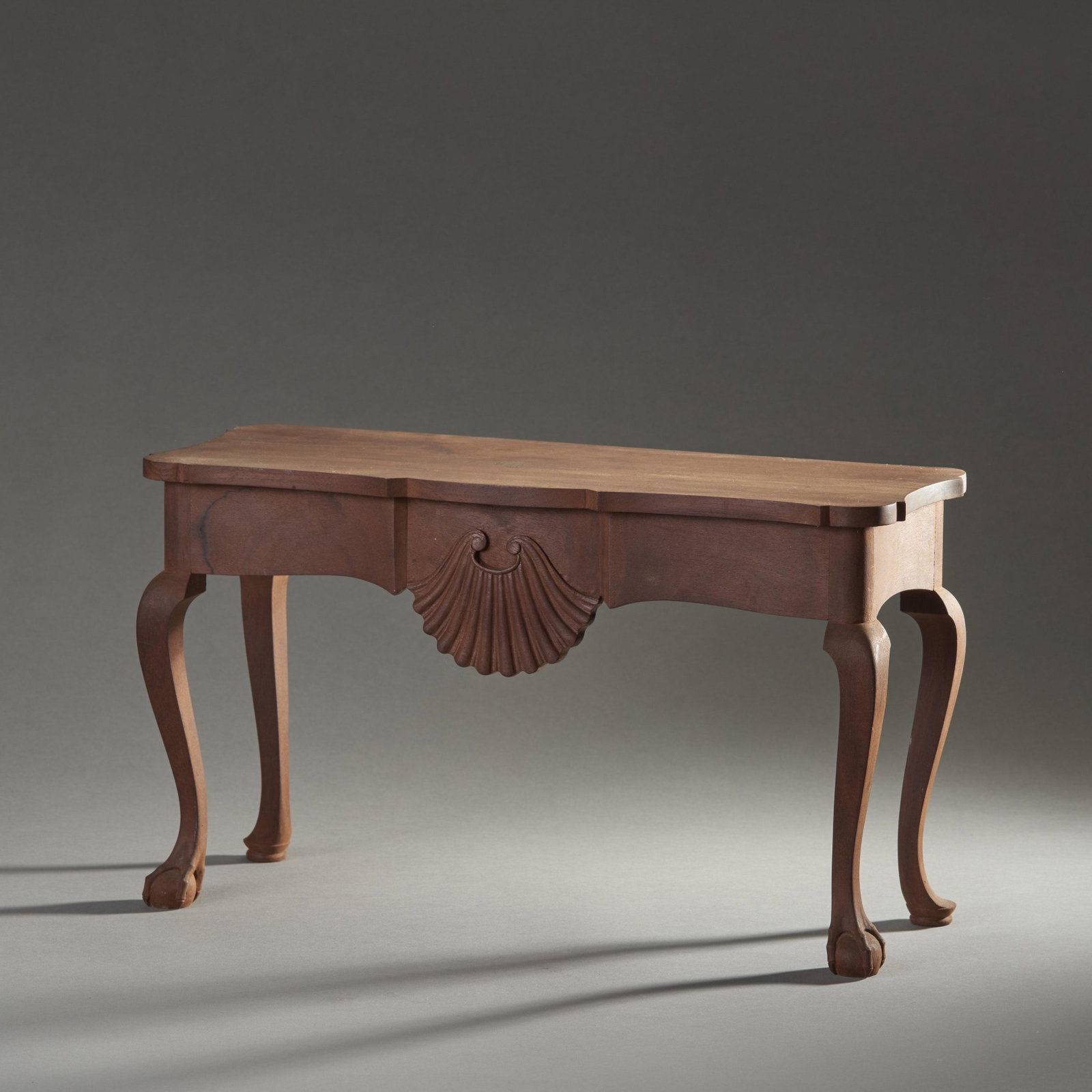 Early Miniature Queen Anne Style Mahogany Console Table: Miniature Hand crafted Queen Anne style mahogany console table having cabriole legs pad feet at rear and ball and claw feet on front and a serpentine apron with central shell carving supporting a shap