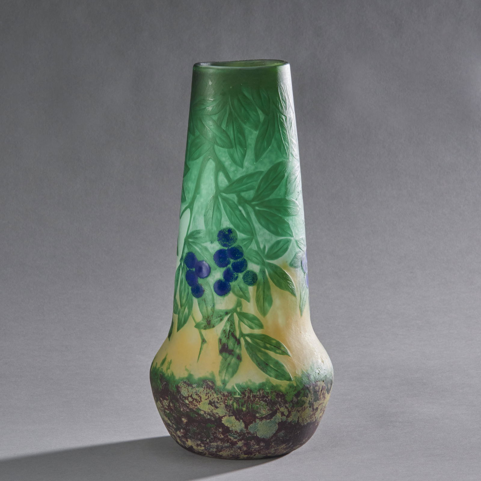 Daum Nancy Cameo Glass Vase: A circa 1900 French hand blown cameo glass vase by Daum Nancy. The vase has an oval tapered form swelling to round at the mottled base decorated with leaves and berries in cameo relief signed Daum Nan