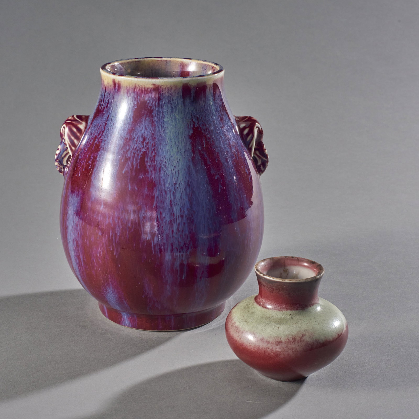 Group Of 2 Chinese Flambe Glazed Vases: Group of 2 flambe glazed vases. 19th century Chinese Vase with elephant handles 8 1/2" height x 6 1/2" diameter excellent condition with minor chips at base small vase with white banding over red 3 1/