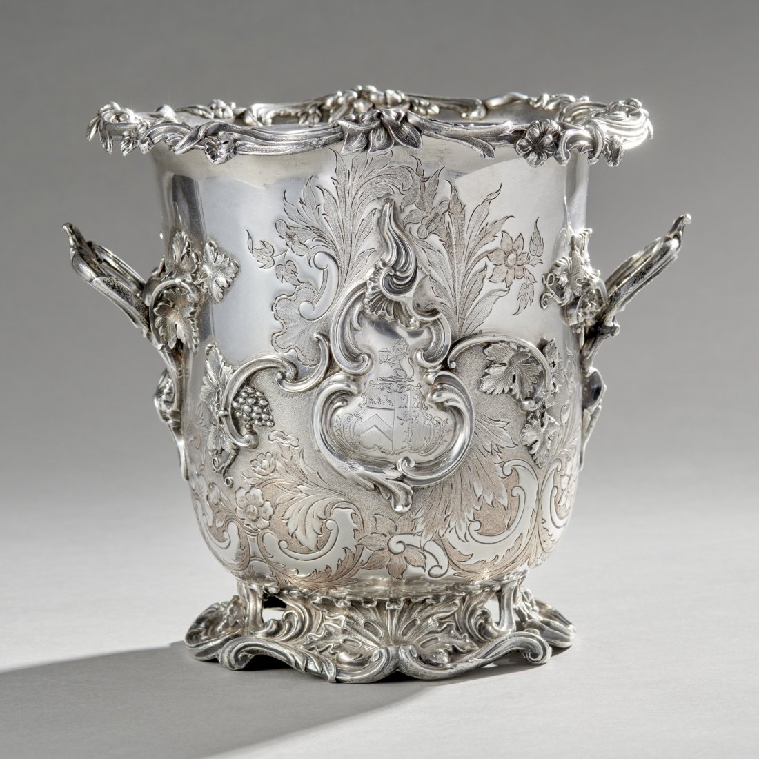 Old English Sheffield Wine Cooler: Old English Sheffield Wine Cooler, circa 1975 London, Paul Lamerie style with a chased body with applied grape and vine decoration having crests on either side and framed within a double-scrolled cart