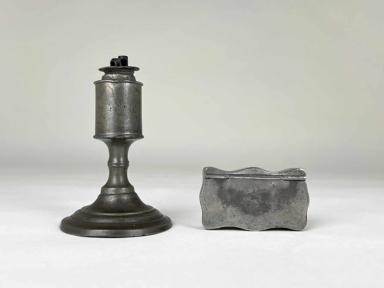 Pewter Whale Oil Lamp and Snuff Box: Calder, Providence 2-wick pewter whale oil lamp features a simple cylindrical design with a removable wick holder. It has a raised circular base and shows signs of natural patina. Hallmarked on the un
