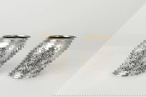 Pair of Tiffany & Co Sterling Silver Art Nouveau Cups: Pair of sterling silver cups with gold wash interior, each with repousse scene of foliage with dragonflies, grasshoppers, and fish jumping out of the water; Tiffany & Co hallmarks on undersid