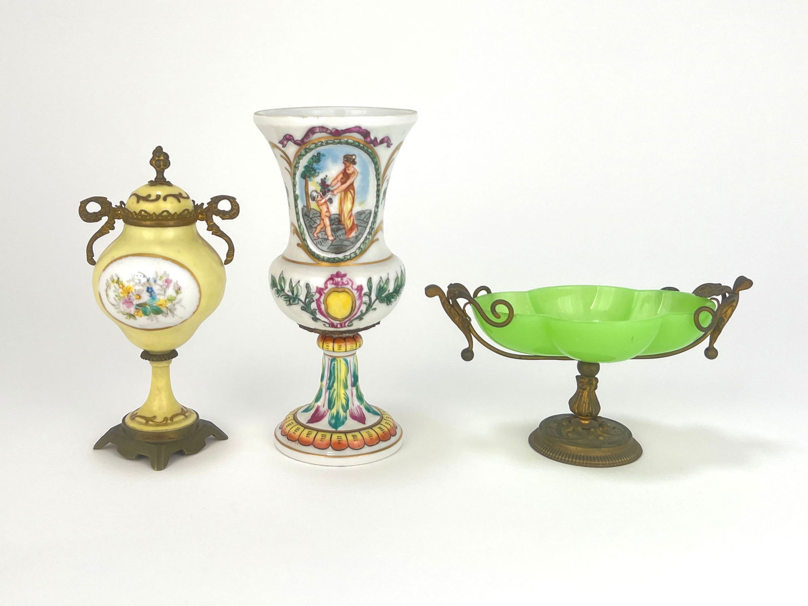 Three Decorative Objects: Pair of decorative porcelain vases and one green glass and brass stand compote. One vase is 7'' x 3.5'' and the other is 6.5'' x 3.5''. Total weight is 18.1 oz. Both ar