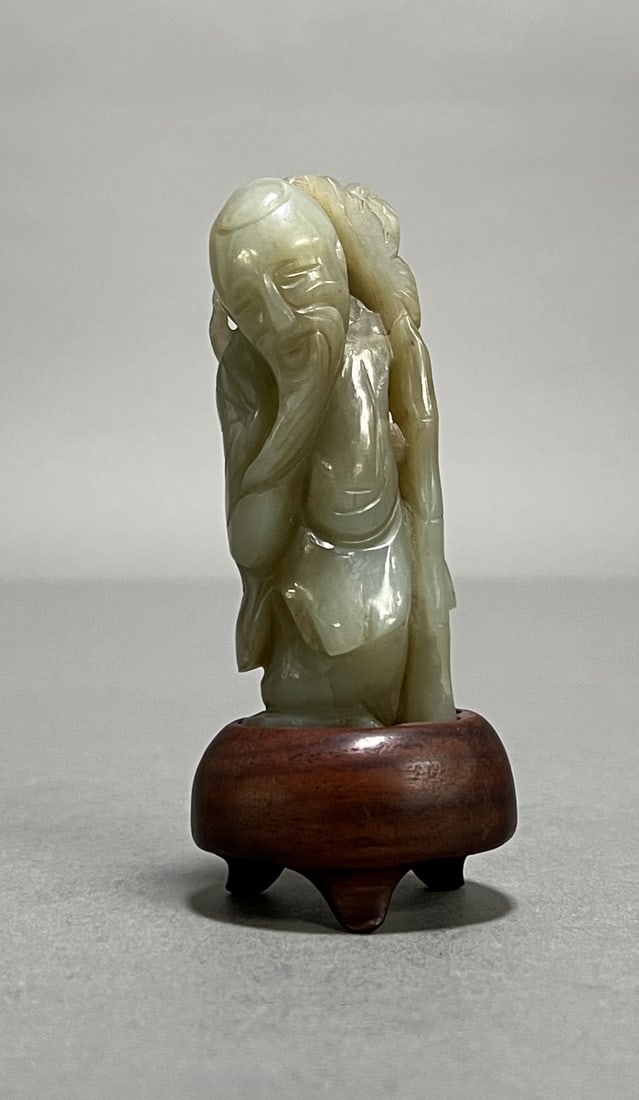Early Chinese Carved Jade Sage/Scholar: Early Chinese carved jade figurine made depicting a sage or scholar figure, mounted on wooden stand. Dimensions: Height: 3.75 in. (including stand) Width: 1.5 in. Weight: 4 oz.