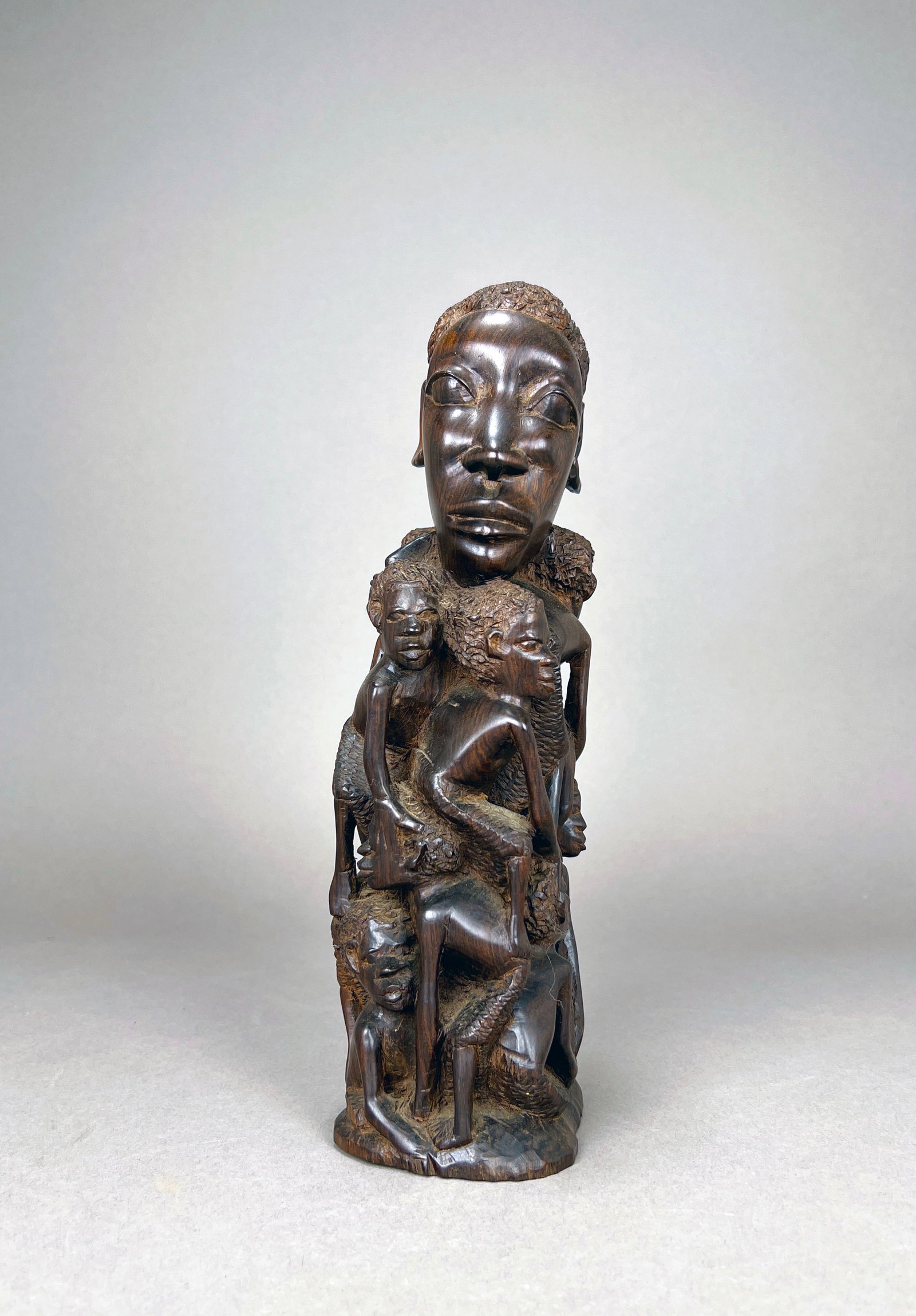 African Mother and Child Sculpture: An African Makonde style figural "tree of life" wooden carving depicting a mother and child. Dimensions: 12.25'' H x 3.75'' W